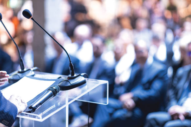 A speaker addressing an audience at a formal meeting, symbolising how AGMs in Tunisia serve as a key platform for transparency, shareholder dialogue, and corporate accountability.